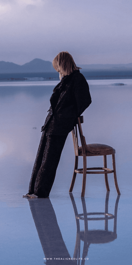 woman leaning on a chair in low water purple mountains reflection | How To Manifest | The Aligned Life Manifestation Blog