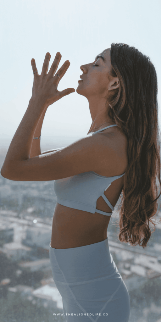 woman doing yoga on the beach | Guide to EFT Tapping | The Aligned Life Manifestation Blog