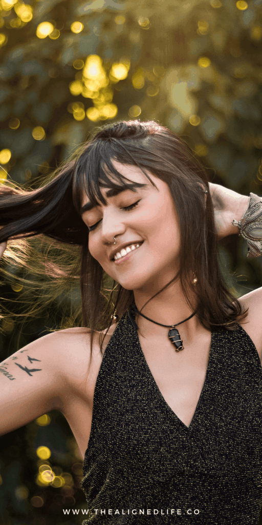 girl with her eyes closed playing with her hair | Most Common Money Manifestation Blocks (& How To Banish Them!) | The Aligned Life Manifestation Blog