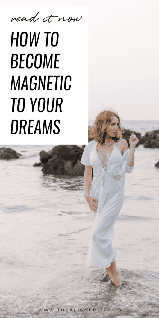 redheaded woman in a white dress standing in water at the beach | How To Become Magnetic To Your Dreams | The Aligned Life Manifestation Blog