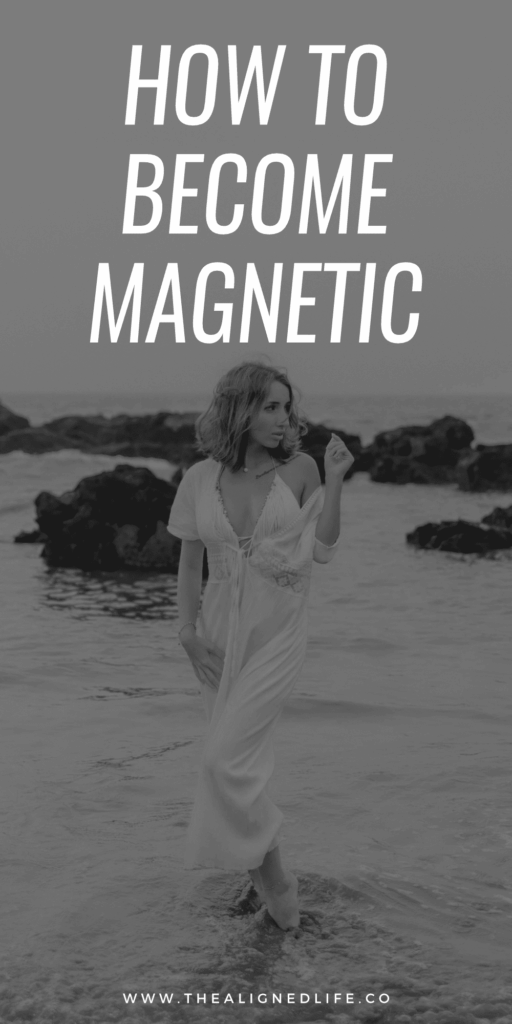 redheaded woman in a white dress standing in water at the beach | How To Become Magnetic To Your Dreams | The Aligned Life Manifestation Blog
