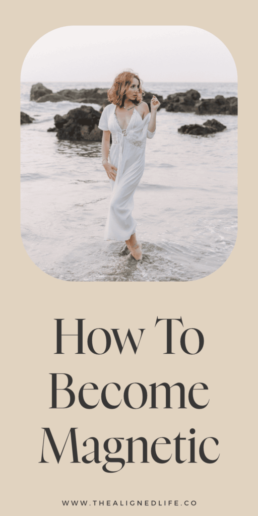 redheaded woman in a white dress standing in water at the beach | How To Become Magnetic To Your Dreams | The Aligned Life Manifestation Blog
