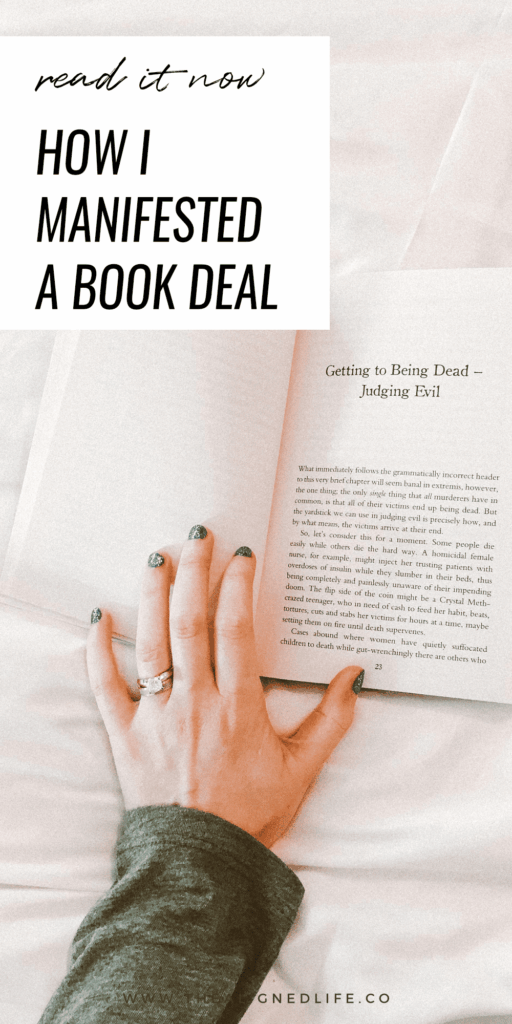 hand on a white bed with a book | How I Manifested A Book Deal | The Aligned Life Manifestation Blog