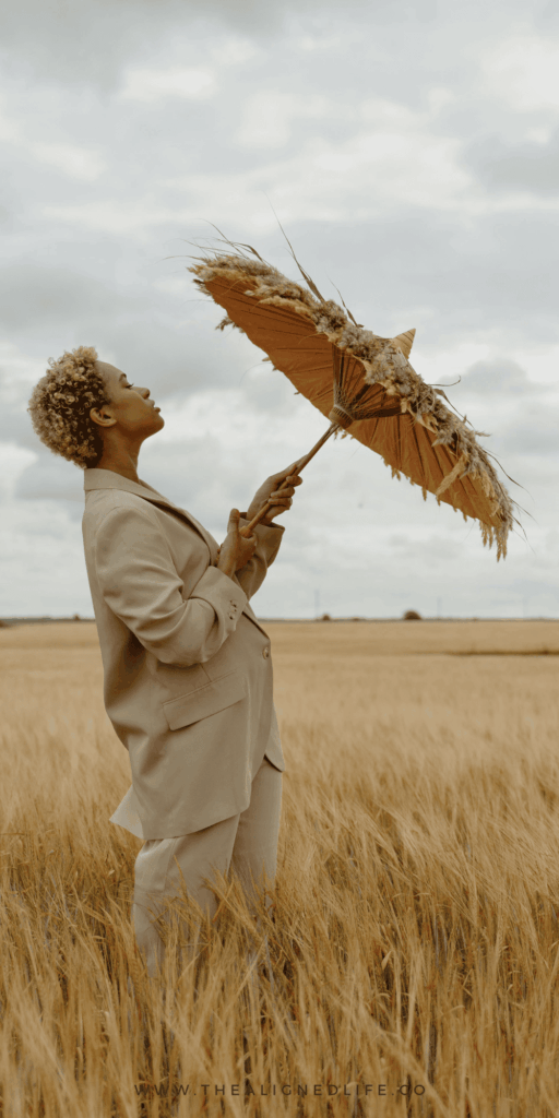 woman in a wheat field with an umbrella | Splenic Authority In Human Design Explained