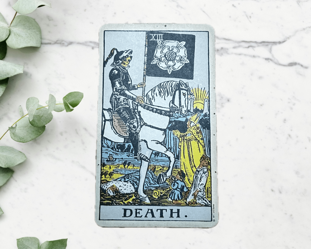 white marble table with eucalyptus & the Death Tarot Card