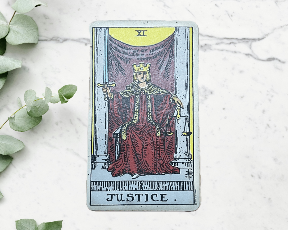 white marble table with eucalyptus & Justice Tarot Card 11