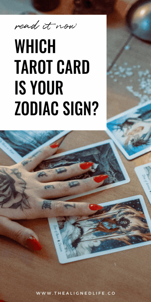 tattooed arm and hand on a tarot card spread What Tarot Card Is Your Zodiac Sign?