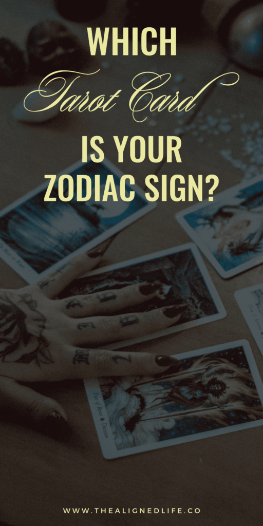 tattooed arm and hand on a tarot card spread What Tarot Card Is Your Zodiac Sign?