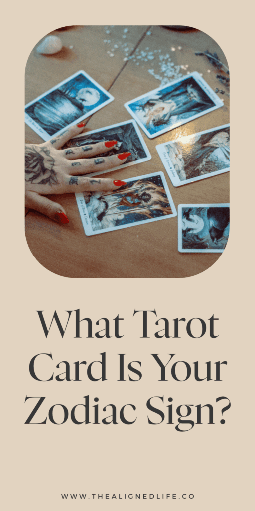 tattooed arm and hand on a tarot card spread What Tarot Card Is Your Zodiac Sign?
